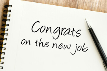 Heartfelt handwritten congratulations message for a new career opportunity, penned on a spiral notepad with a pen, symbolizing professional success