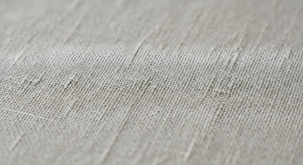 Detailed macro photograph of a soft, natural linen fabric in a light beige color, showcasing the intricate textile weave and texture as an elegant background