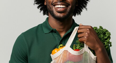 Smiling man in green polo shirt holding a reusable grocery bag filled with vegetables