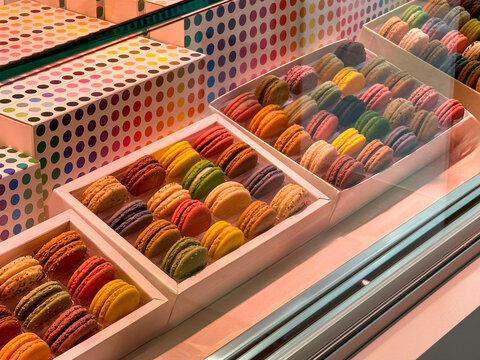 Colorful assortment of French macarons in gift boxes on display in bakery shop window