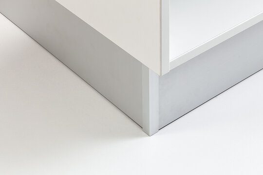 Close-up of kitchen cabinet base showing the kickboard panel and support structure with clean, modern lines.