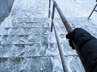 Icy stairs covered in snow dangerous descent winter hazard slippery steps caution risk falling safety handrail outdoor building entrance public space frozen surface accident prevention careful walking
