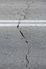 OLD BROKEN AND CRACKED ASPHALT ROAD with dangerously damaged asphalt for the transit of motor vehicles