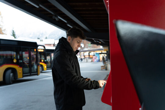 Man buying bus ticket from vending machine