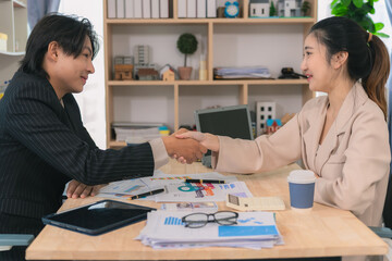 Young man and woman holding hands, cooperation of partners, teamwork or successful company, in a team brainstorming meeting.