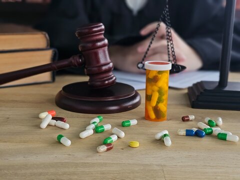 Courtroom scene with prescription pills and gavel showing the intersection of law and healthcare concept