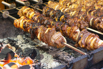 Juicy shashlik grilling over hot charcoal, skewered meat and onions roasting above glowing embers in a close-up shot.