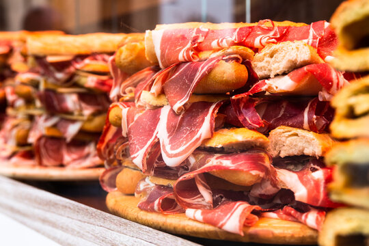 ham hanging from sandwiches in a store window