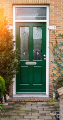 Facade of typical Dutch door house with brick walls, steps, front door windows. Doors on the street, Netherlands