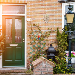 Facade of typical Dutch door house with brick walls, steps, front door windows. Doors on the street, Netherlands