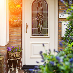 Facade of typical Dutch door house with brick walls, steps, front door windows. Doors on the street, Netherlands