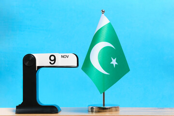 Calendar from November 9th and flag Pakistan on blue background. Iqbal Day, holiday in Pakistan dedicated to birthday philosopher and poet Muhammad Iqbal.
