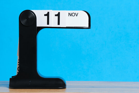 Desktop calendar with date November 11th on blue background. Veterans Day. Space for text.