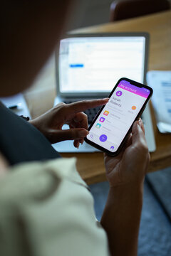 Adult focused on mobile banking app at home office