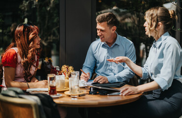 Colleagues share a lively conversation at an outdoor cafe, jotting notes and exchanging documents. The scene captures teamwork, friendly mood, and a productive business meeting in a relaxed setting.