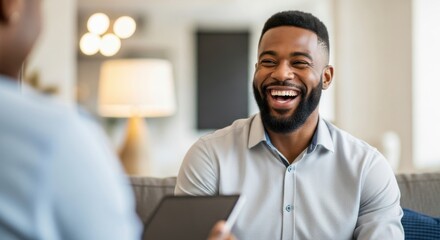 Happy man laughing during conversation with tablet