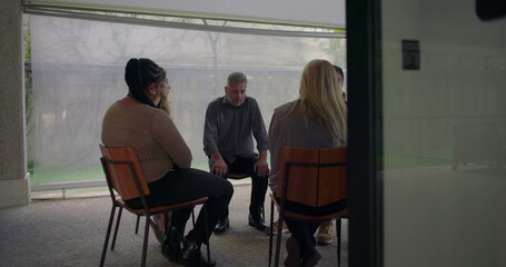 Fototapeta premium Emotional testimony shared by man in support group, heartfelt confession delivered with expressive body language in intimate circle setting