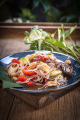 A vibrant Thai Som Tum with rice noodles presented in a rustic still life setting. Fresh vegetables, bold spices, and authentic textures ideal for food concepts, menus, culture, and culinary visuals.