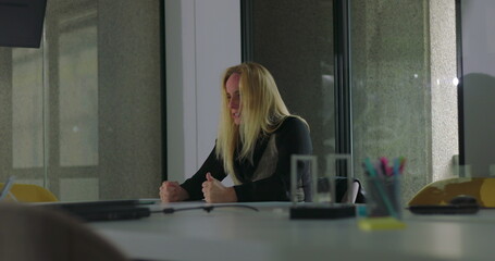 Enraged businesswoman slams both fists on conference table in outburst of anger, head down with...