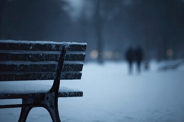 Snow-covered park bench in a quiet winter landscape with blurred figures in the distance