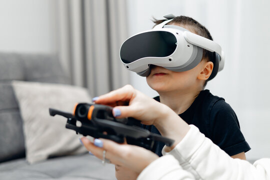 Caucasian child engaged with virtual reality headset and drone controller indoors