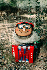 a Tio de Nadal standing with a red accordion