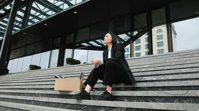 Unemployed and Alone A Woman Sitting on Stairs with a Cardboard Box