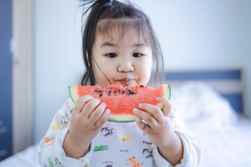 Cute little Asian girl is eating watermelon,Happy Child girl eating Watermelon with white background,Children's Day.