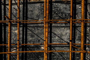 Close-up of rusted steel rebar used in reinforced concrete construction. The image shows the texture and structure of building materials on-site.