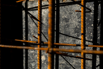Close-up of rusted steel rebar used in reinforced concrete construction. The image shows the texture and structure of building materials on-site.