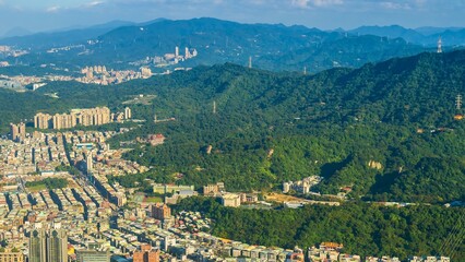 Aerial view of a city nestled against lush green mountains