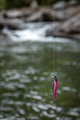 長野県南牧村の渓流とピンク色のルアー（ミノー）のクローズアップ

