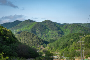 長野県南牧村の里山風景と青空、5月の新緑の山々
