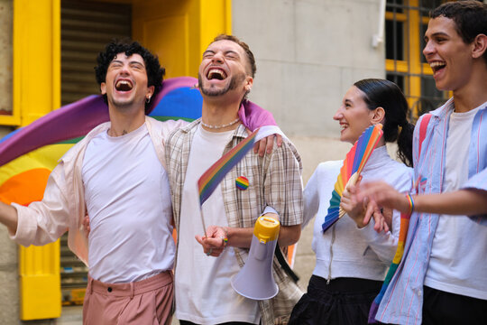 Young diverse friends enjoying a lively pride parade, smiling and showing LGBTQ plus support - Powered by Adobe
