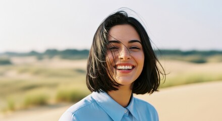Smiling woman with windblown hair in desert landscape
