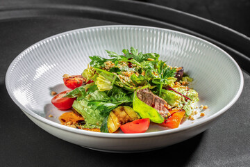 Fresh mixed green salad with grilled vegetables, tender beef slices, cherry tomatoes and crunchy topping, restaurant menus, healthy food promotions and culinary advertising