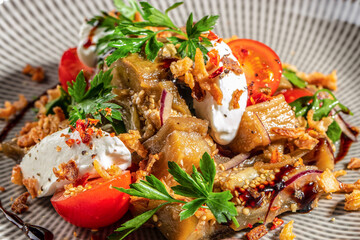 Delicious roasted eggplant salad with creamy cheese, cherry tomatoes, fresh herbs and crispy toppings drizzled with balsamic glaze, perfect for restaurant menu