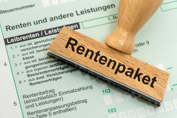 Ein Holzstempel ist beschriftet mit dem Aufdruck Rentenpaket als Symbolbild für Reformen im...