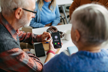 Tutor teaching seniors about phone scams and digital safety.
