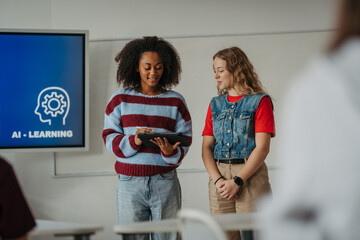 Teen girls presenting AI learning project in classroom.