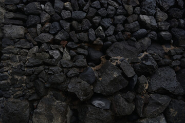 Dark, rough and elegant rock texture surface closeup. Black abstract rustic nature pattern for horizontal background or backdrop.