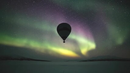 Hot air balloon silhouette floating under a vibrant green aurora borealis in a starry winter night sky - Powered by Adobe