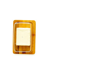 Cut block of fresh butter in wooden butter dish, top view