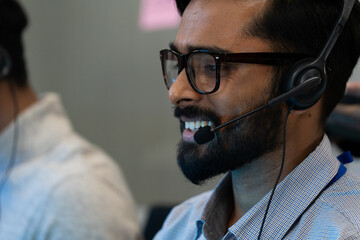 Customer support team in a modern call center receiving guidance from a supervisor. Diverse employees working with headsets and computers, representing teamwork, communication, and business 
