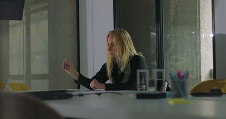 Frustrated businesswoman slams hand on conference table in anger, overwhelmed during workplace crisis, head bowed with hair falling forward, surrounded by scattered items