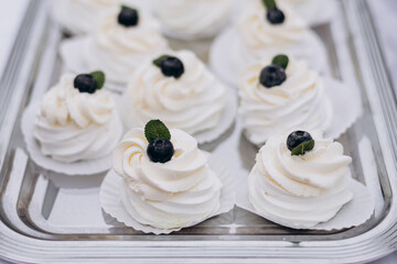 Elegant pavlova dessert topped with fresh blueberries and served on a tray.