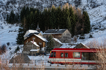 Eisenbahnzug passiert den Weiler Zumdorf im Urserental, Kanton Uri, Schweiz