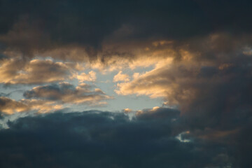 Sunbeams break dramatically through dense clouds in the sky.