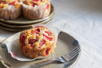 Homemade strawberry white chocolate muffins on a handmade clay plate.