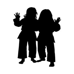 Silhouette of two young girls practicing martial arts together in uniforms